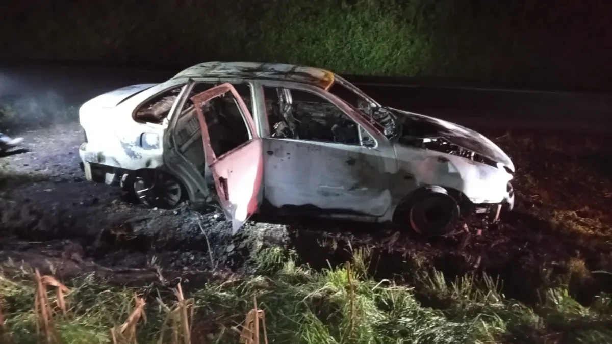 VW Polo destruído pelo fogo na PR-493 durante investigação de homicídio em Bom Sucesso do Sul.